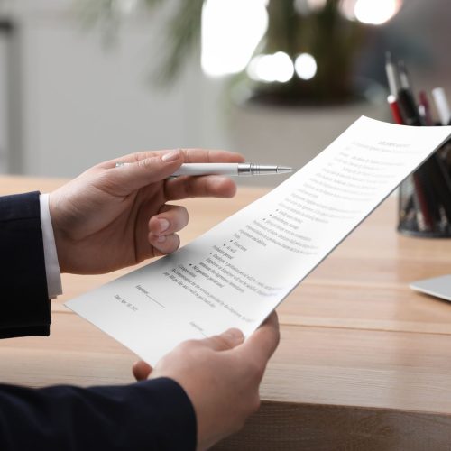 Man,Reading,Document,At,Table,In,Office,,Closeup.,Signing,Contract